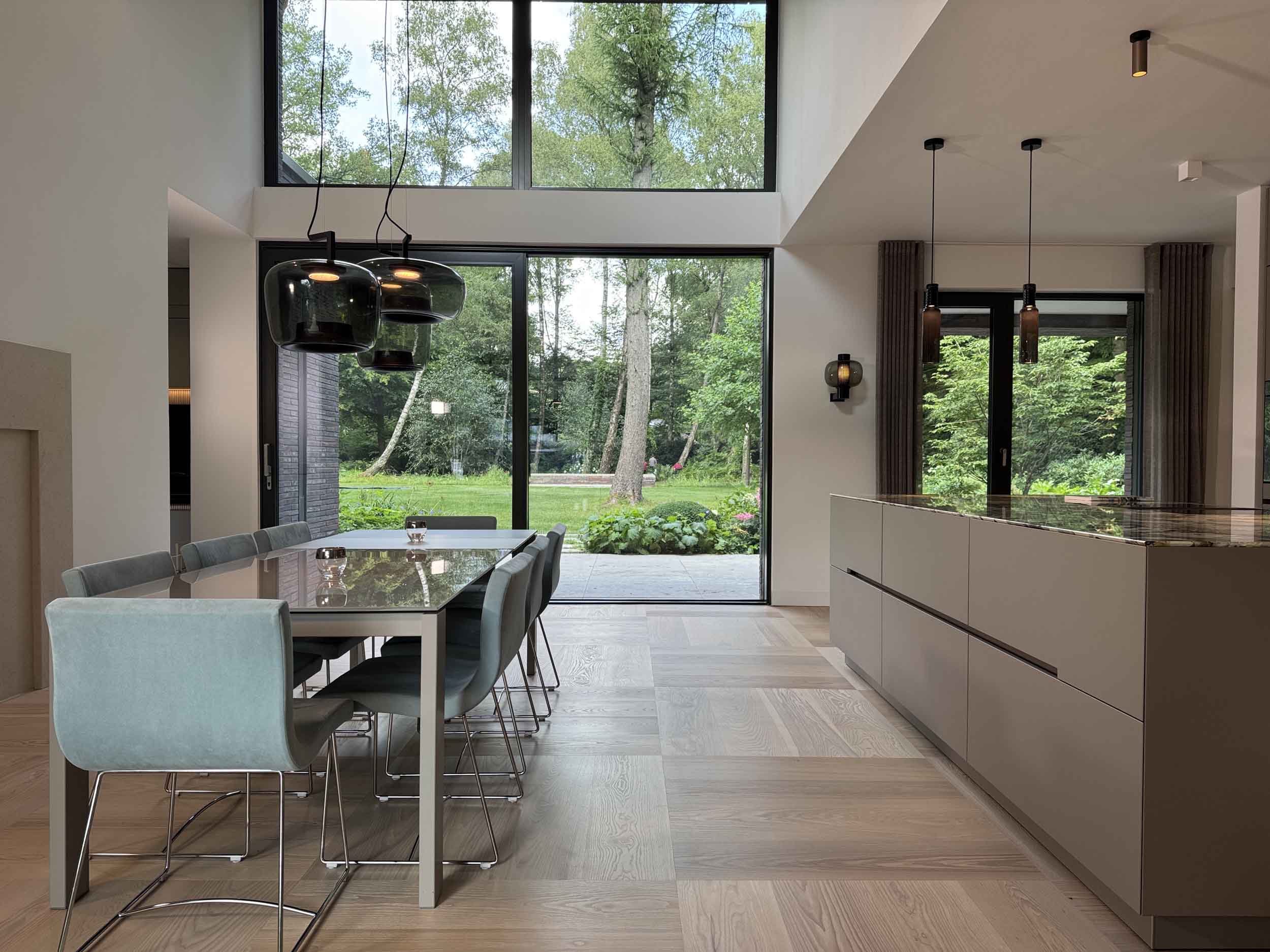 interior-design-hamburg-weisselberg-kitchen-and-interior_4 Essbereich mit raumhoher Fensterfront zum Garten und angrenzendem Küchenblock